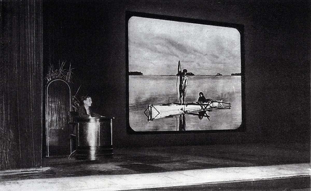 Imagem no interior de um cinema com um filme preto e branco projetado
