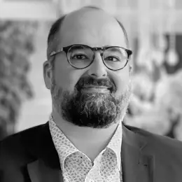 Homem branco, careca, com barba e bigode.